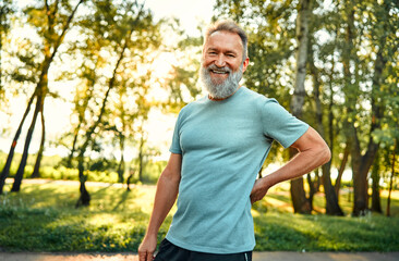 Sport during leisure. Portrait of caucasian pensioner in light blue t-shirt smiling and looking at...