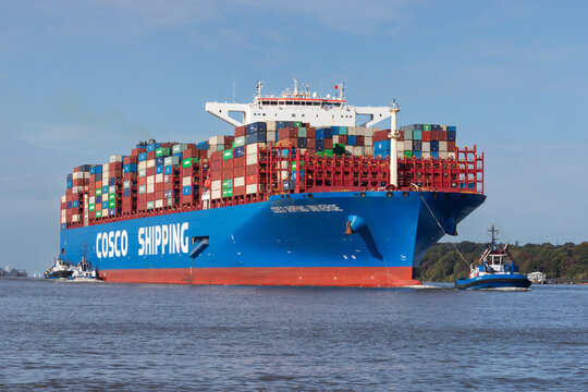Der Containerriese Cosco Shipping Universe auf der Elbe beim Einlaufen in den Hamburger Hafen mit drei Schleppern. Hamburg, Deutschland am 8. Oktober 2023.