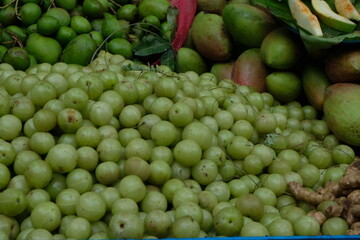Pile of raw amla and mangoes.