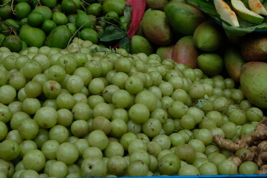 Pile of raw amla and mangoes.