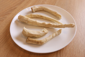Peeled horseradish roots on a white plate