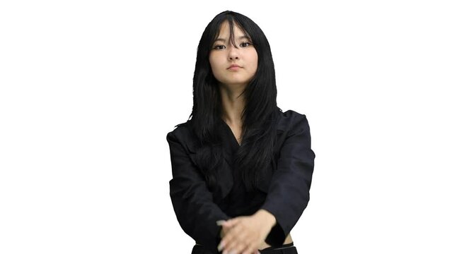 A girl in black clothes, on a white background, close-up, shows a pause sign