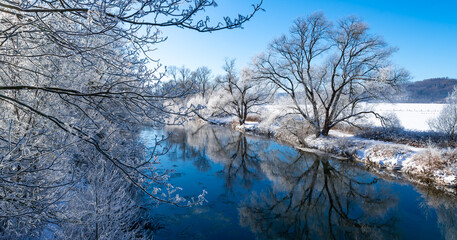 Winter panorama in Sauerland at Ruhr river near Arnsberg and Wickede. Frosted trees and fields on a...
