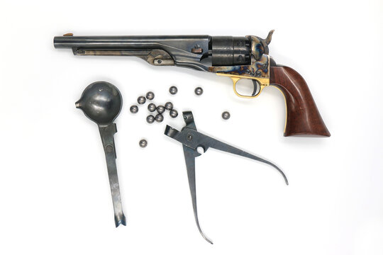 Black powder percussion revolver Colt 1860 Army and the equipment such as a spoon for melting lead, a mold for bullets and lead bullets on a white background. Left side.