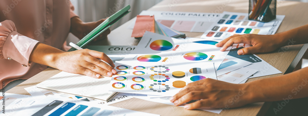 Poster skilled architect searching data from tablet while selecting an appropriate color from color wheel a