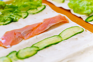 Cooking an appetizer with salmon and vegetables in pita bread