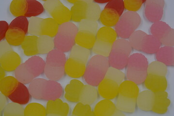 Bright and high-quality children's, marmalade candies in the form of bright fruits, such as: raspberry, pineapple, strawberry, cloudberry, currant located on a white background.