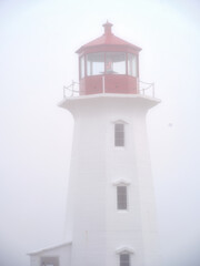 The beautiful Peggys Cove Lighthouse on the coast of Nova Scotia in thick fog