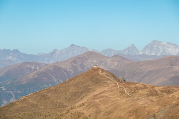 Scenic view of mountain cottage on summit of Helm (Monte Elmo) in Carnic Alps, border Austria Italy. Looking from Hornischegg, South Tyrol. Distant view of mount Hochgall (Monte Collalto), High Tauern
