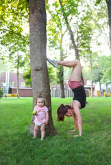 Young woman exercising with her baby in park