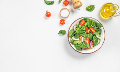 Healthy vegan salad from green leaves mix and fresh tomato on a white background. organic healthy products. Detox and clean diet concept. copy space, top view
