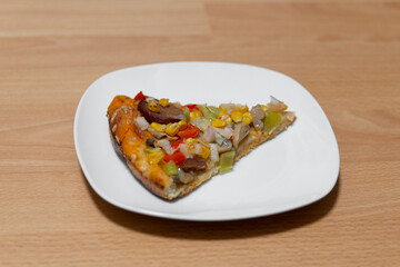 Ein Stück Pizza auf dem Teller