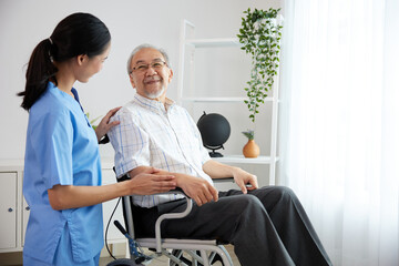 Fototapeta premium nurse or caregiver beside elderly man sitting on wheelchair at home