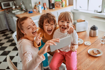 Happy family taking a selfie in the kitchen