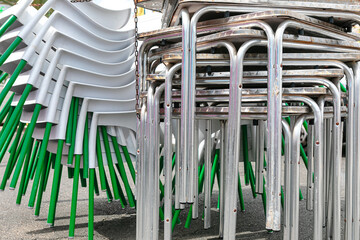Stainless steel chairs stacked in a row on a street terrace