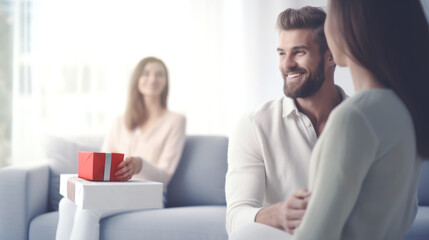 Happy couple hugging on background of lonely woman sitting with gift on sofa