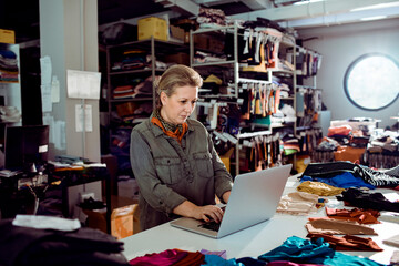 Fashion Designer Enjoying Work on a Laptop in Her Studio