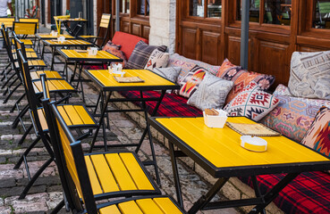Street view of a coffee terrace with tables and chairs. Free cafe table. Outdoor empty coffee and...