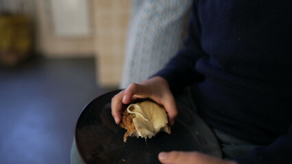 Young boy eating bread with cheese, child takes a bite of carb food during afternoon snack