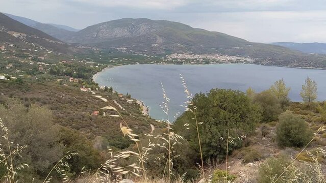 view of ancient epidavros a coastal town in greece (seen from the top of a hill with grass blowing in the wind) harbor, bay, seaside, sea, peloponnese, mediterranean