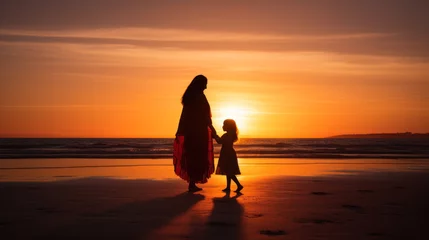  A silhouette of a mother and child holding hands at a sunset beach © Paula