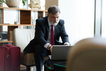 Businessman looking busy working on laptop. Thoughtful business professional reading emails on laptop in office lobby - Powered by Adobe