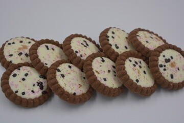 Delicious branded, factory-made, chocolate chip cookies with white fudge, fruit pieces, chocolate pieces arranged on a white background.