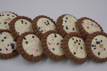 Delicious branded, factory-made, chocolate chip cookies with white fudge, fruit pieces, chocolate pieces arranged on a white background.