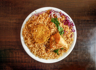 Spicy Chicken pulao with shami kabab onion and cabbage served in plate isolated wooden background top view indian spices and pakistani food