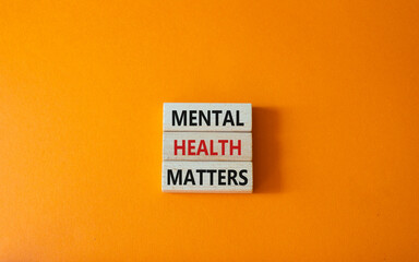 Mental Health Matters symbol. Concept words Mental Health Matters on wooden blocks. Beautiful orange background. Healthcare and Mental Health Matters concept. Copy space.