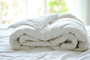 Fototapeta na wymiar White folded duvet lying on white bed