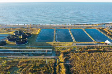 neAerial view of modern sewage treatment plant by the sea. Industrial water treatment with round...
