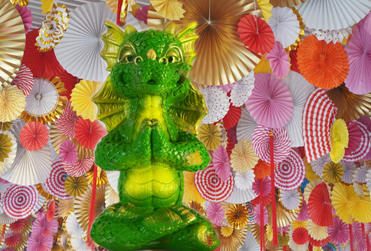 The symbol of the Chinese New Year 2024  is a green dragon against the background of colorful decorative Chinese fans.
