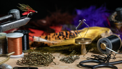 Tying a fly fishing fly. A set of various accessories and materials for tying fly fishing lures....