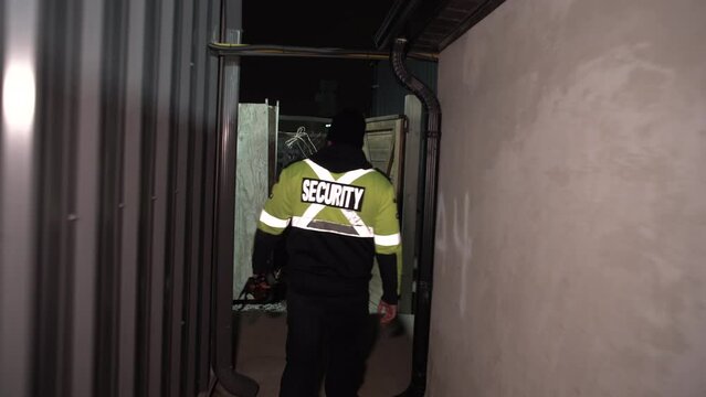 Security guard patrolling commercial site at night as a fire watch
