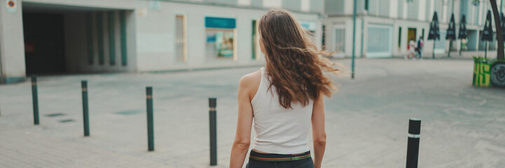 Girl walks down the city street with her pet.