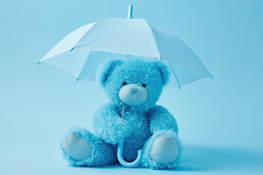 Blue teddy bear with umbrella on blue background. Blue monday concept