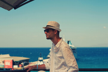 Fototapeta premium A tourist at the beach is looking the sea 