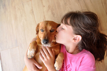 menina criança feliz com cachorro caramelo doméstigo, amor canino, cão amigo e companheiro 