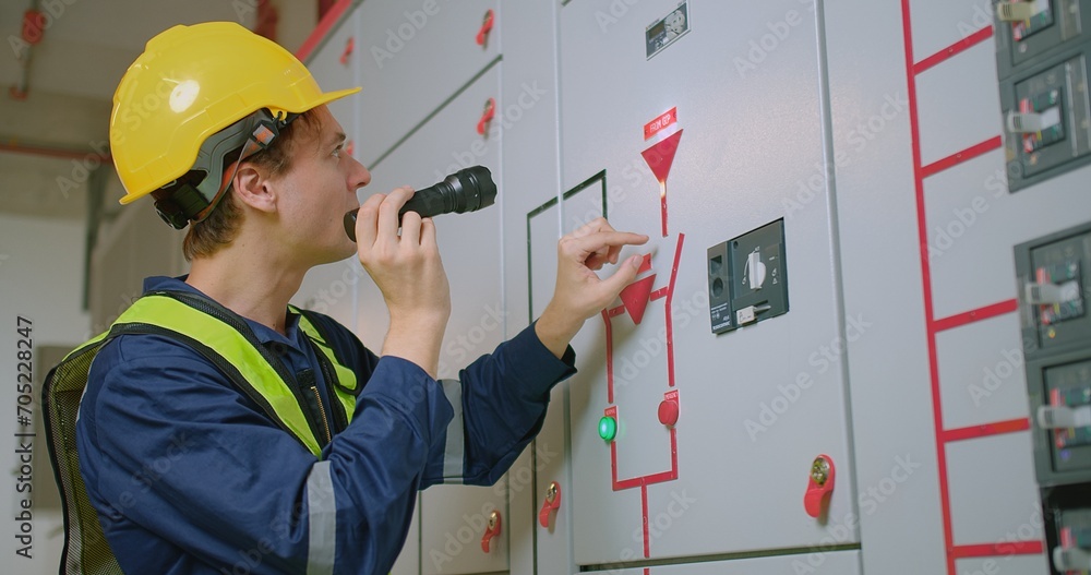 Wall mural electricians electrical engineer in protective uniform wearing hard hat checking voltage control pan - Wall murals