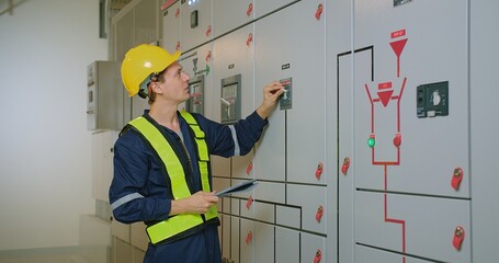 electricians electrical engineer in protective uniform wearing hard hat checking voltage control panel system at electrical cabinet for generate electricity of factory in manufacture industrial - obrazy, fototapety, plakaty
