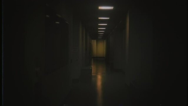 Dark Hallway Walk Eerie Retro Corridor VHS Effect Tracking Shot. Walking through an eerie dark corridor flickering lights, retro VHS effect. Tracking shot