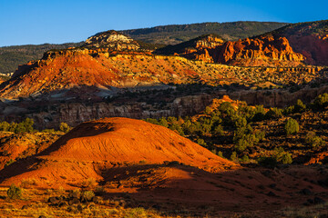 Red rock cliffs of national park Capitol Reef illuminated by a strong sunlight in Utah early in the morning.