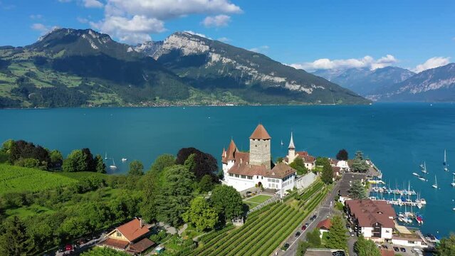 Aerial panoramic view of Spiez Church and Castle on the shore of Lake Thun in the Swiss canton of Bern at sunset, Spiez, Switzerland. Spiez Castle on lake Thun in the canton of Bern, Switzerland.