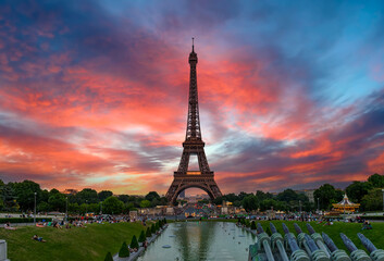 View of Eiffel Tower from Jardins du Trocadero in Paris, France. Eiffel Tower is one of the most iconic landmarks of Paris. Sunset cityscape of Paris - obrazy, fototapety, plakaty