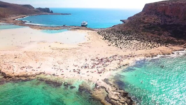 Stunning view of greek coastline on crete with tourists on beach and ferry