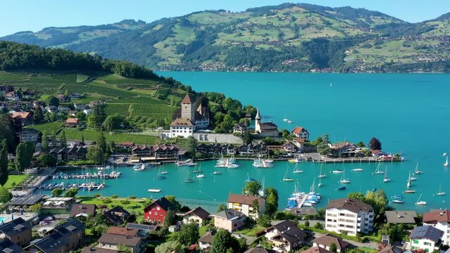 Aerial panoramic view of Spiez Church and Castle on the shore of Lake Thun in the Swiss canton of Bern at sunset, Spiez, Switzerland. Spiez Castle on lake Thun in the canton of Bern, Switzerland.