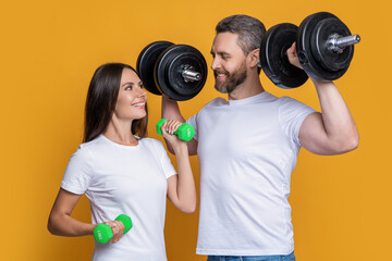 Couple of strong sporty sportswoman and sportsman. Woman man do sport training exercise isolated on yellow. Athlete couple with barbell and dumbbell. Family sport. Fitness gym - obrazy, fototapety, plakaty