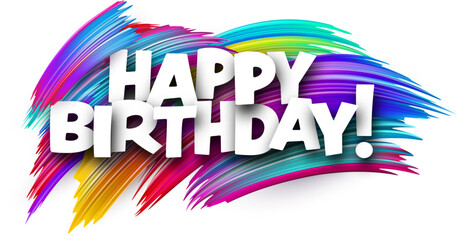 Happy birthday paper word sign with colorful spectrum paint brush strokes over white.
