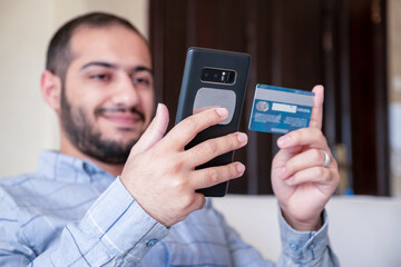 muslim man paying online through mobile phone application